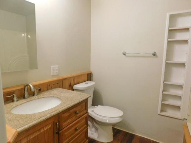 bathroom featuring vanity, hardwood / wood-style flooring, and toilet