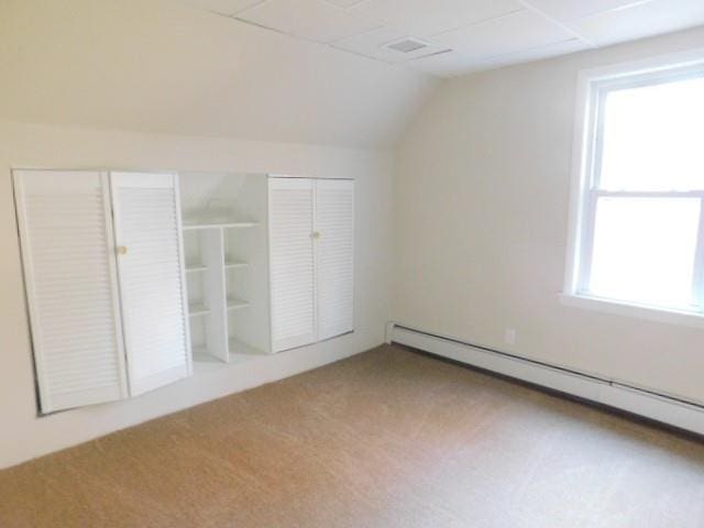 bonus room with plenty of natural light, carpet floors, baseboard heating, and lofted ceiling