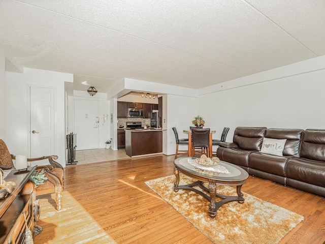 living room with light hardwood / wood-style floors and a textured ceiling