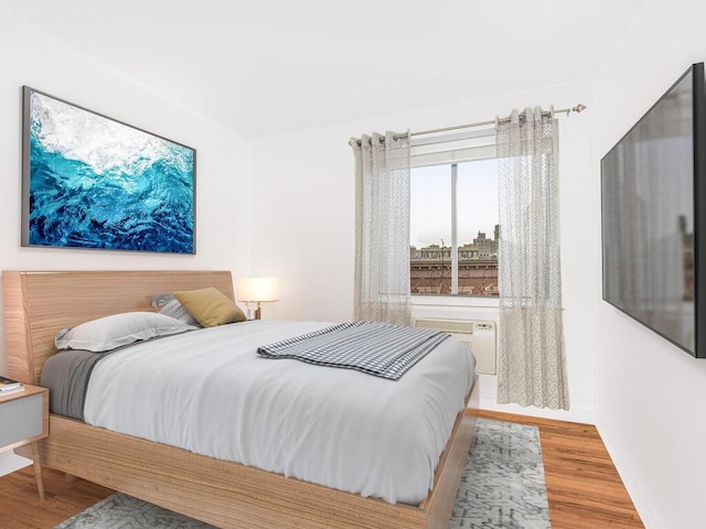 bedroom featuring an AC wall unit and wood-type flooring