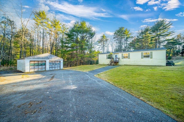 view of front facade featuring a garage, an outdoor structure, and a front yard