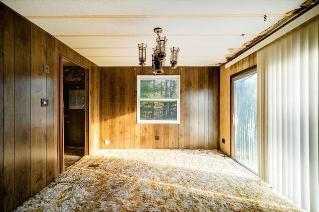 40 Collins Rd, Eldred, NY 12732 - unfurnished dining area featuring a chandelier, carpet floors, and wood walls