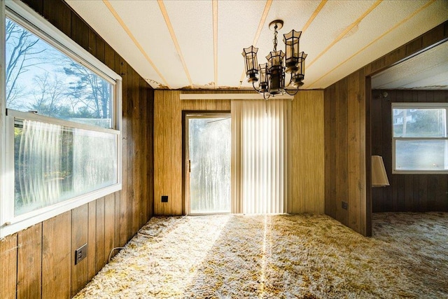 40 Collins Rd, Eldred, NY 12732 - unfurnished dining area featuring wood walls, carpet flooring, and a chandelier