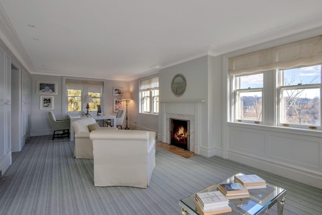 living room with carpet floors, ornamental molding, and a fireplace