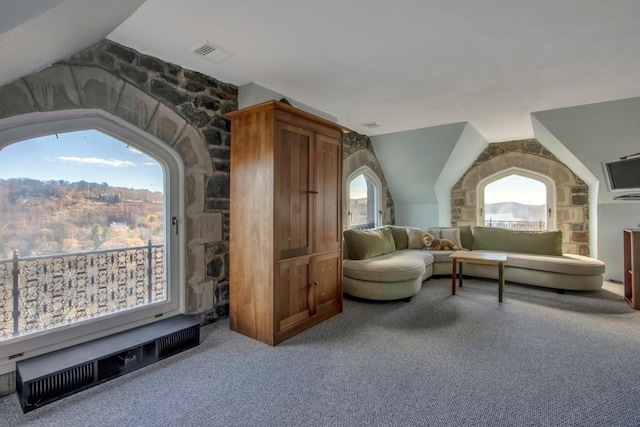 sitting room with carpet floors and vaulted ceiling