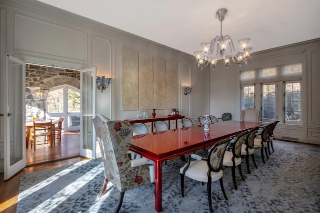 dining space featuring french doors, ornamental molding, a chandelier, and hardwood / wood-style floors