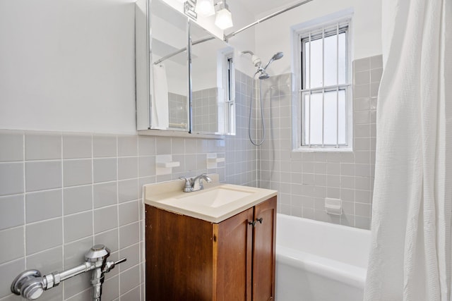 bathroom featuring vanity, shower / bath combo with shower curtain, and tile walls