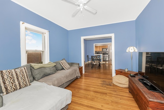 living room with hardwood / wood-style floors, ceiling fan, and ornamental molding