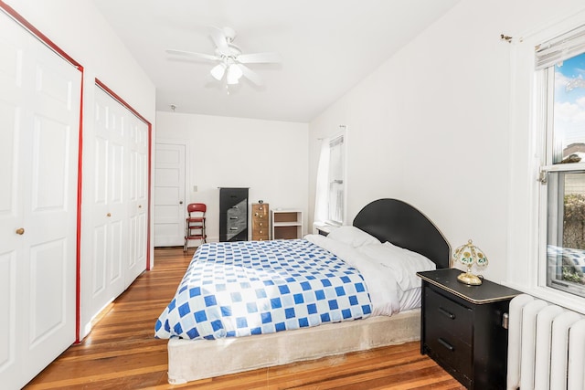 bedroom featuring radiator heating unit, dark hardwood / wood-style floors, and ceiling fan