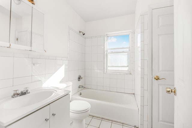 full bathroom featuring tiled shower / bath combo, tile patterned flooring, toilet, vanity, and tile walls