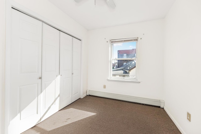 unfurnished bedroom with carpet floors, a closet, baseboard heating, and ceiling fan