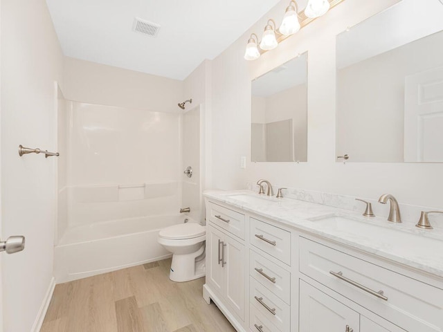 full bathroom with hardwood / wood-style floors, vanity, toilet, and shower / washtub combination