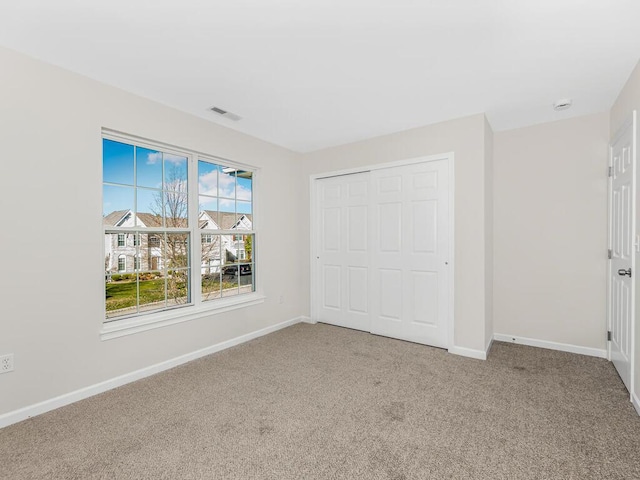 unfurnished bedroom featuring carpet and a closet