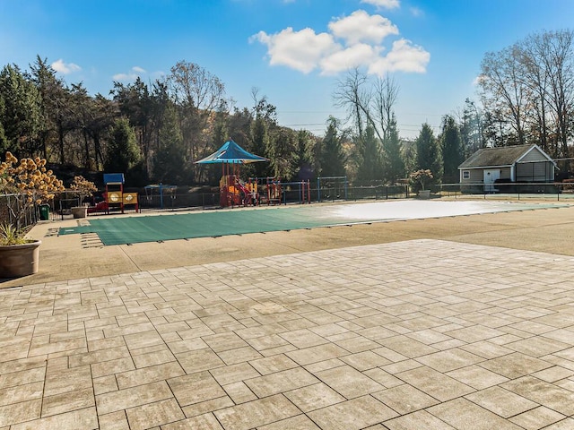 view of pool featuring a playground and a patio