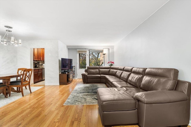 living room with light hardwood / wood-style floors and an inviting chandelier