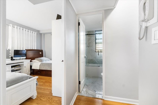 bedroom with hardwood / wood-style floors and ensuite bath