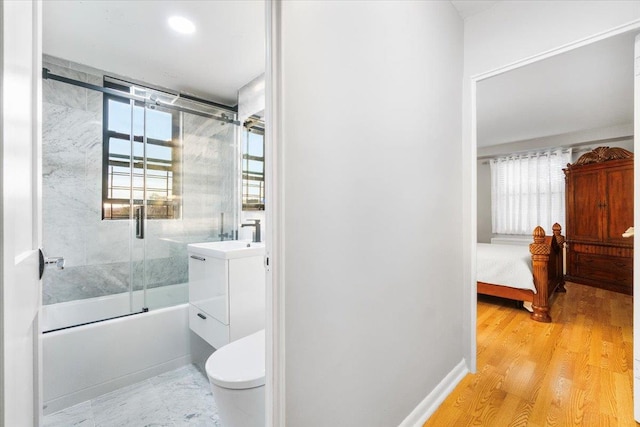 full bathroom featuring toilet, vanity, enclosed tub / shower combo, and hardwood / wood-style flooring