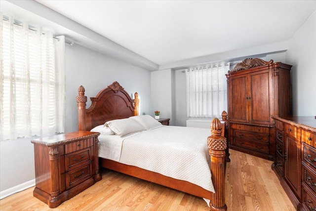 bedroom featuring multiple windows and light hardwood / wood-style floors