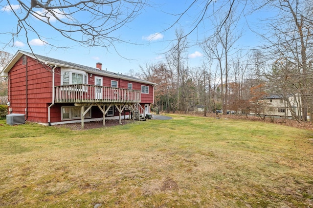 back of house featuring central air condition unit, a deck, and a lawn