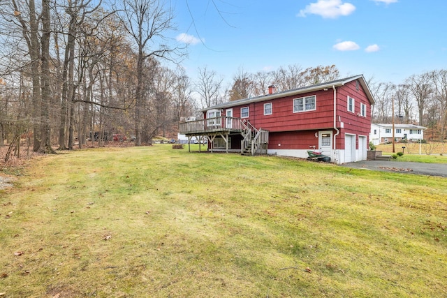 exterior space with a lawn, a wooden deck, and a garage