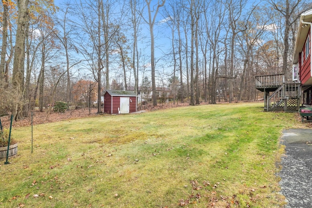 view of yard featuring a storage unit and a wooden deck