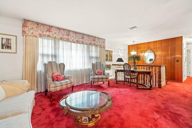 carpeted living room featuring wooden walls