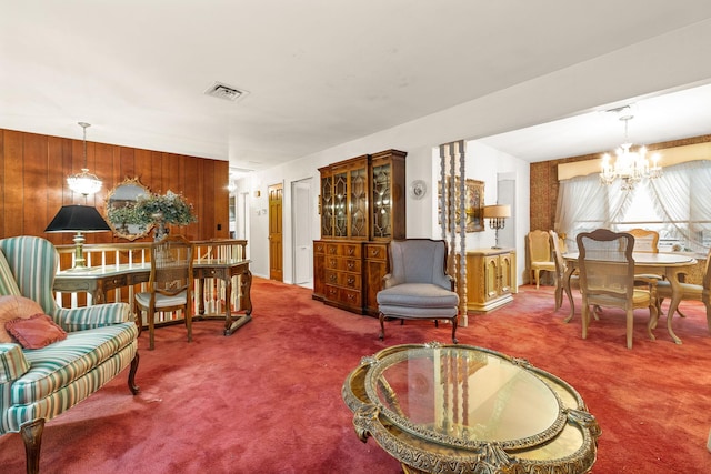 carpeted living room featuring wooden walls and a chandelier