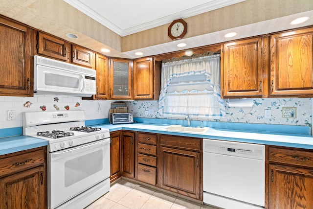 kitchen with light tile patterned flooring, white appliances, crown molding, and sink