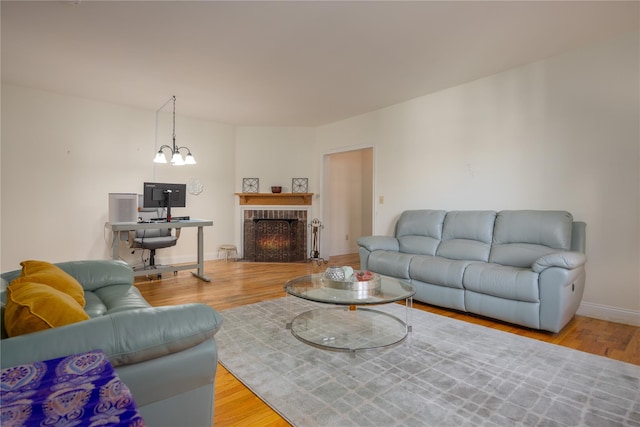 living room featuring hardwood / wood-style floors, a notable chandelier, and a fireplace