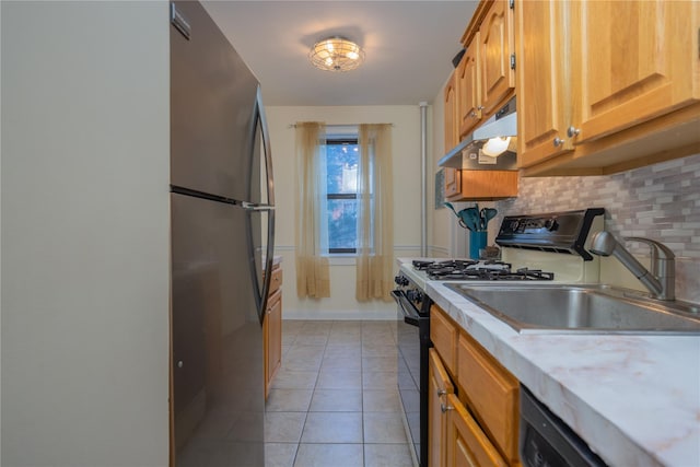 kitchen with light tile patterned flooring, sink, backsplash, and appliances with stainless steel finishes