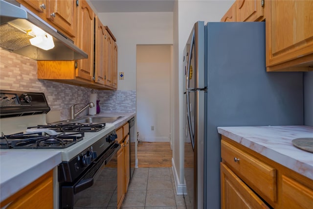 kitchen featuring light tile patterned flooring, sink, tasteful backsplash, and black appliances