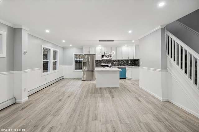 kitchen with a baseboard heating unit, white cabinets, light wood-type flooring, appliances with stainless steel finishes, and a kitchen island