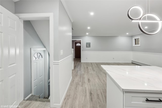 kitchen with light stone countertops, crown molding, pendant lighting, light hardwood / wood-style flooring, and white cabinets