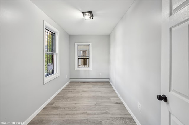 unfurnished room featuring light wood-type flooring and a baseboard radiator