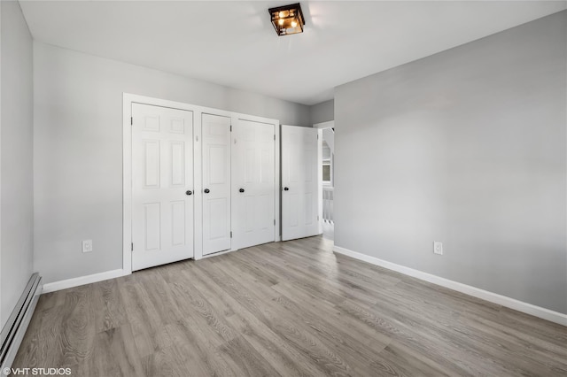 unfurnished bedroom featuring light hardwood / wood-style floors and baseboard heating