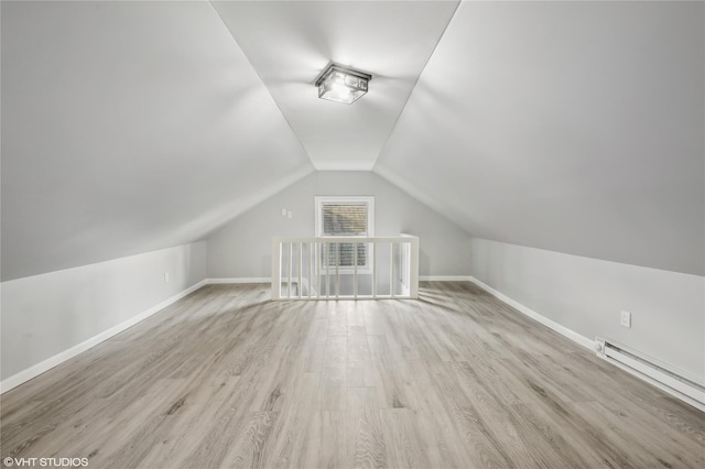 additional living space with light hardwood / wood-style floors, lofted ceiling, and baseboard heating