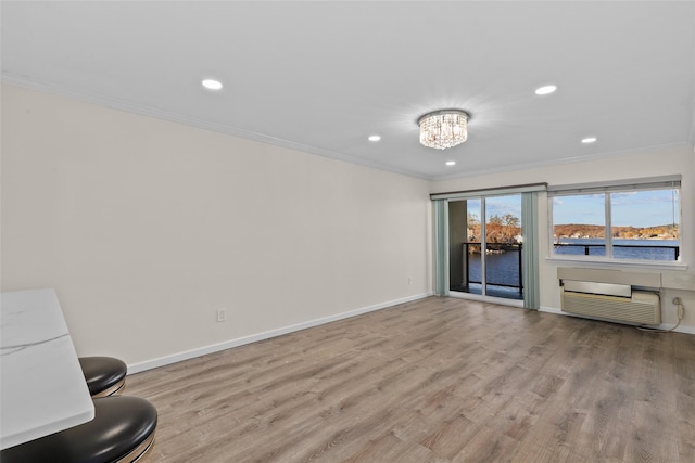 interior space featuring a wall mounted AC, light hardwood / wood-style flooring, an inviting chandelier, and ornamental molding