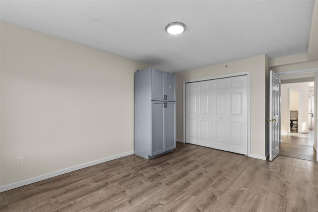 unfurnished bedroom featuring a closet and light hardwood / wood-style flooring