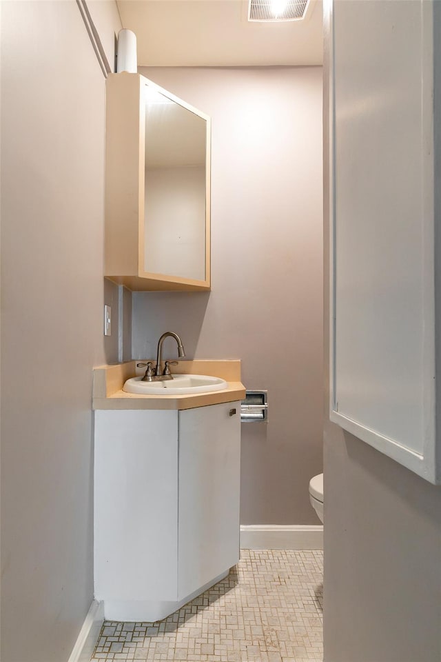 bathroom featuring tile patterned flooring, vanity, and toilet