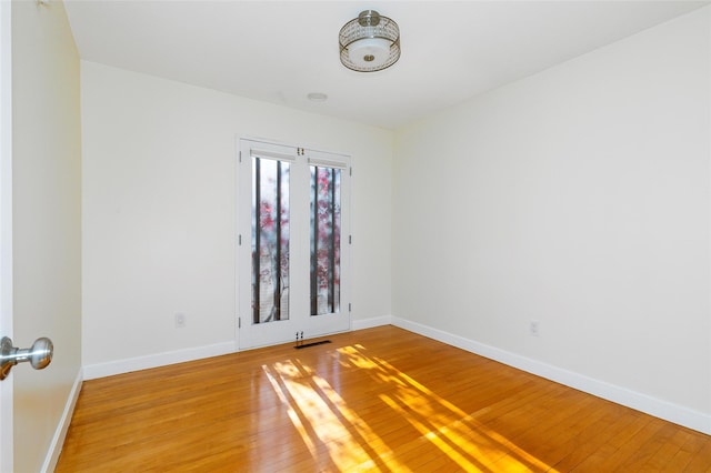 unfurnished room with hardwood / wood-style flooring