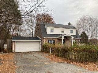 dutch colonial featuring a garage, a gambrel roof, and driveway