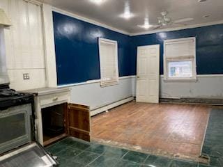 kitchen with stainless steel gas range oven, ceiling fan, dark hardwood / wood-style floors, and a baseboard heating unit