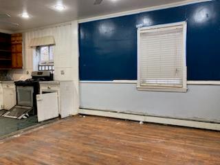 kitchen featuring hardwood / wood-style floors, stainless steel electric range, and a baseboard radiator