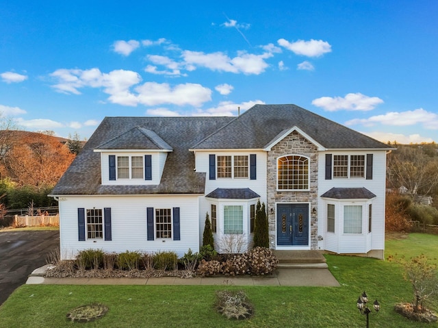 view of front of house featuring a front lawn and stone siding