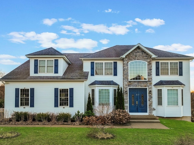 view of front of property with stone siding and a front yard