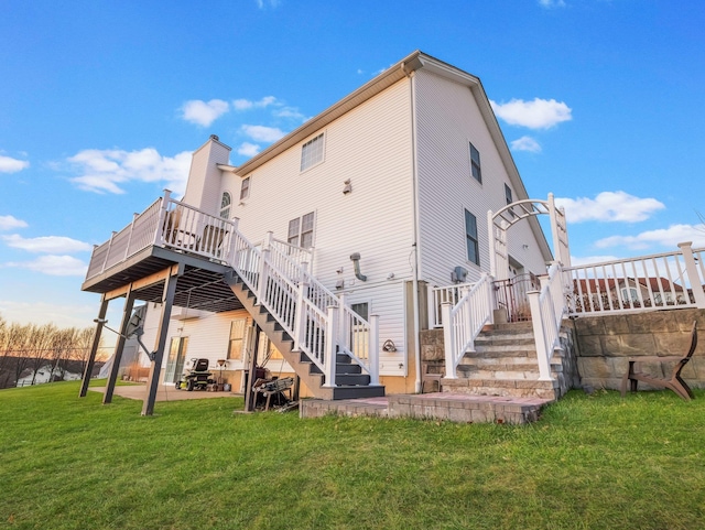 rear view of house featuring stairway, a wooden deck, a lawn, a patio, and a chimney