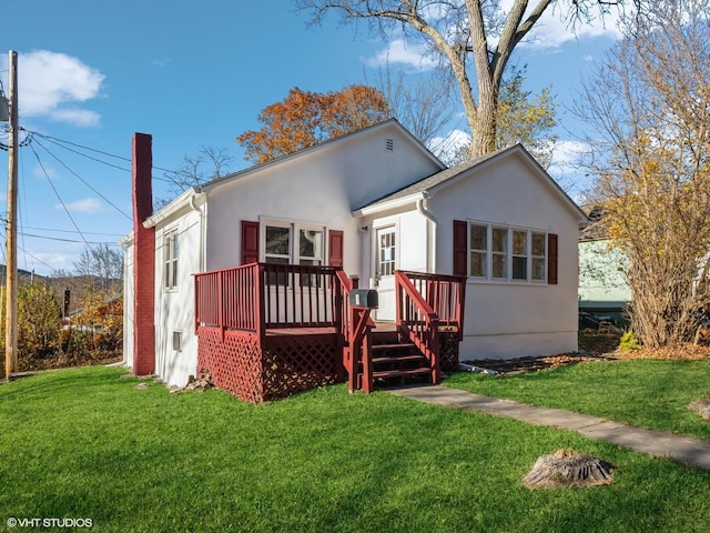 rear view of house featuring a deck and a lawn