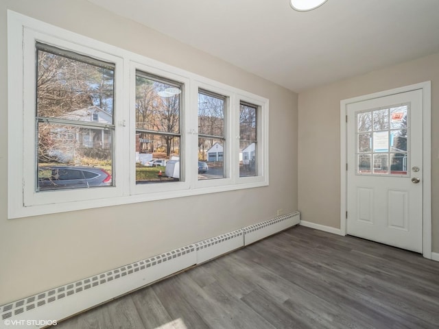 entrance foyer featuring dark hardwood / wood-style flooring, plenty of natural light, and a baseboard heating unit