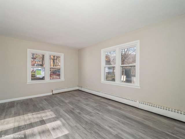 spare room featuring light wood-type flooring and a baseboard radiator