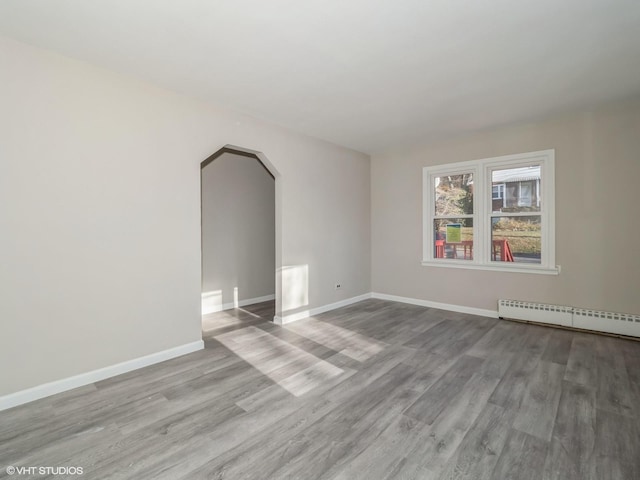 unfurnished room with a baseboard radiator and light hardwood / wood-style flooring